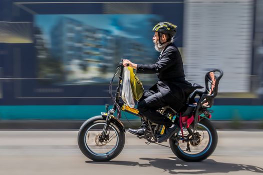 Powerful electric bike climbing steep city bridge with commuter rider
