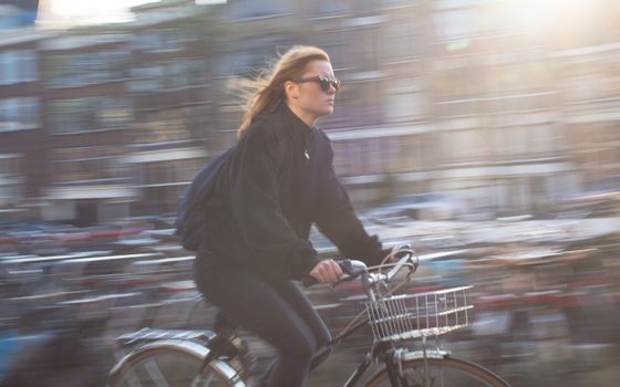Woman over 50 riding step-through eBike on paved bike path