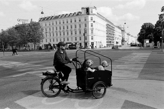 Parent riding converted cargo eBike with child seat in Amsterdam