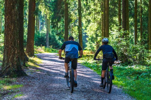 Rider climbing steep dirt trail on electric mountain bike with mid-drive motor